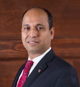 Moin injury attorney headshot over brown wood background