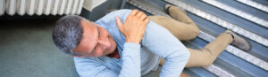 man falling down stairs with shoulder injury