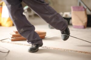 Trabajador tropezando con un cable suelto en una construcción, representado para un abogado de accidentes por resbalones y caídas en Nueva York.