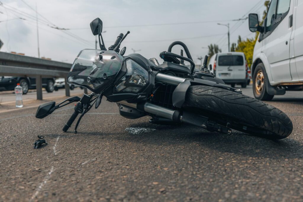 Motocicleta dañada tras una colisión en una carretera transitada de Nueva York, representando los riesgos que enfrentan los motociclistas en la ciudad.