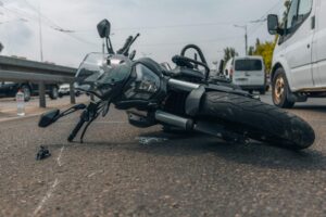Motocicleta dañada tras una colisión en una carretera transitada de Nueva York, representando los riesgos que enfrentan los motociclistas en la ciudad.