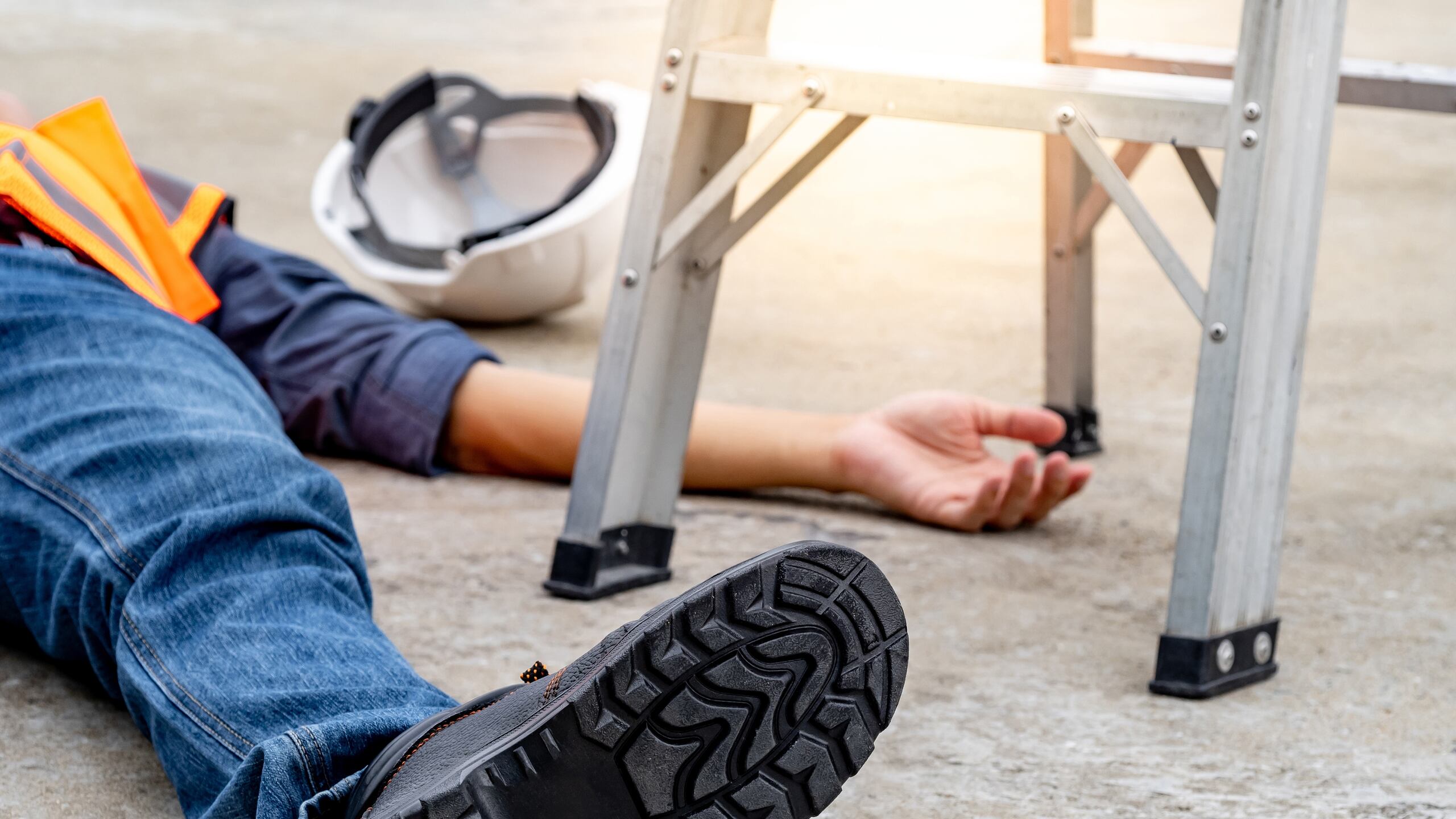 An injured worker on a New York job site next to an unsecured ladder, highlighting the need for internal safety inspection reports to prove negligent supervision.