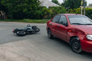 Accidente de moto en una intersección de Nueva York provocado por un conductor con cobertura de responsabilidad insuficiente.