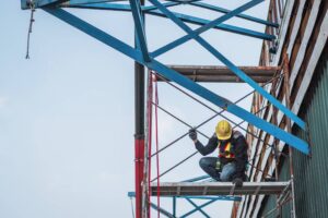 A construction worker on a high-elevation scaffold in New York, demonstrating the gravity-related risks protected under Labor Law 240.