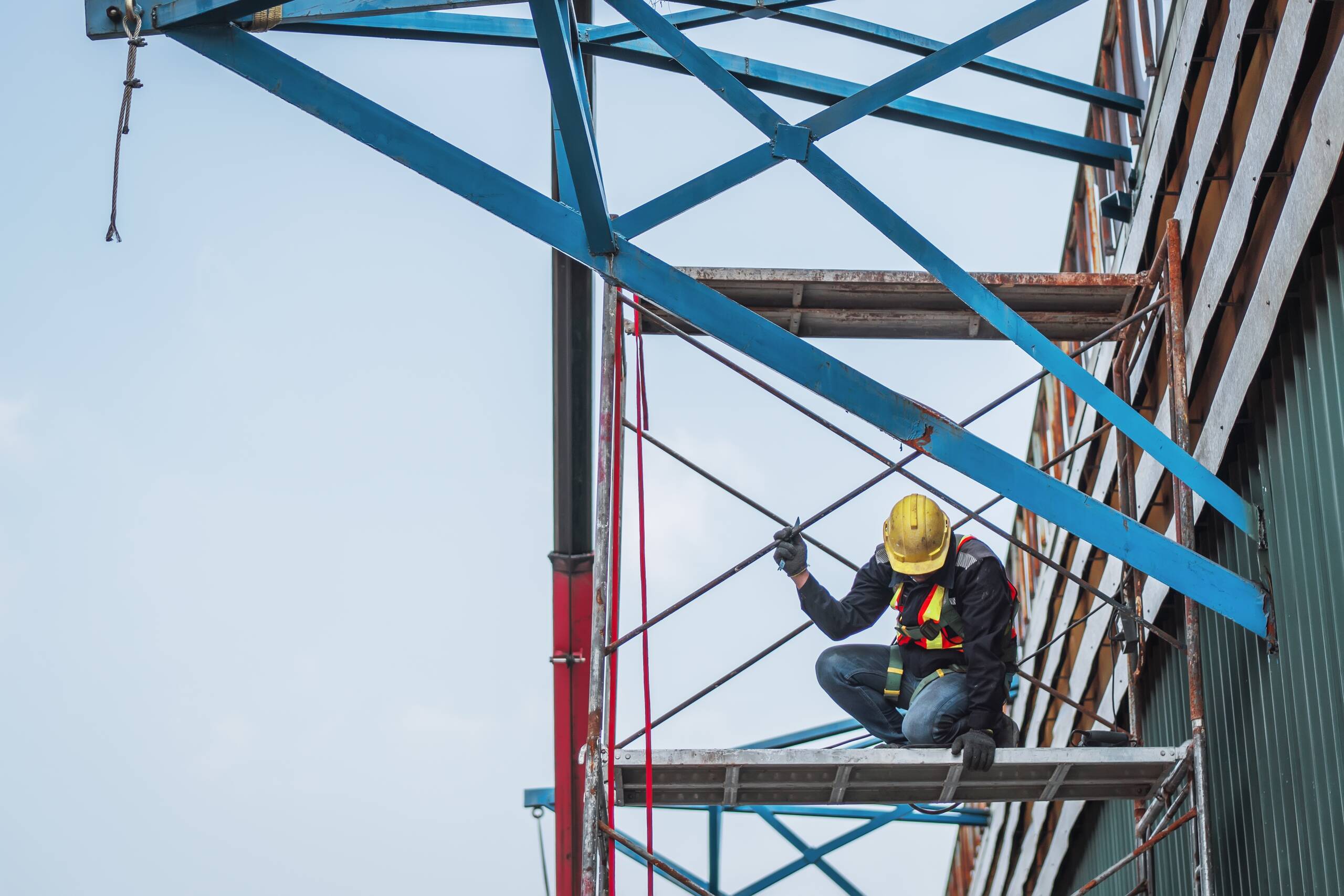 A construction worker on a high-elevation scaffold in New York, demonstrating the gravity-related risks protected under Labor Law 240.