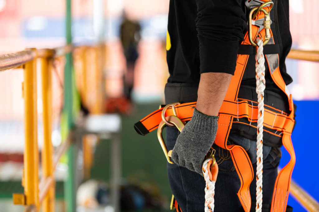 ew York construction worker using a safety harness to prevent falls from heights on a high-rise project.