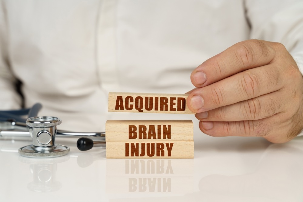 Wooden blocks spelling acquired brain injury with a doctor's stethoscope