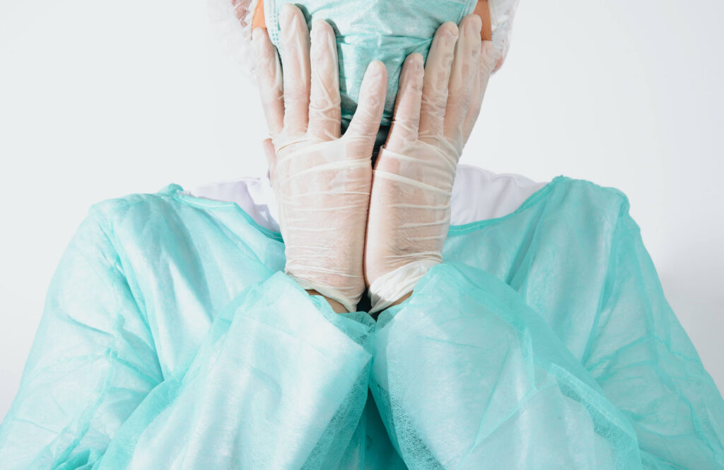 Cirujano cubriéndose el rostro con las manos tras cometer errores quirúrgicos en hospitales de NYC.