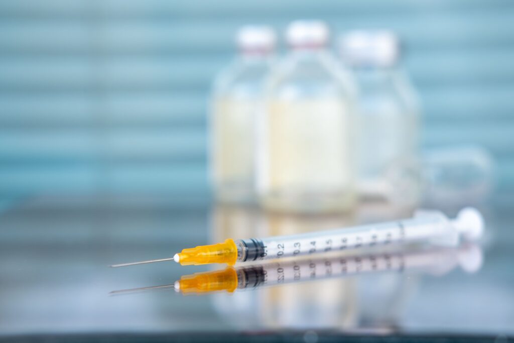 Jeringa médica y frascos sobre una mesa analizados por un New York medical malpractice lawyer.