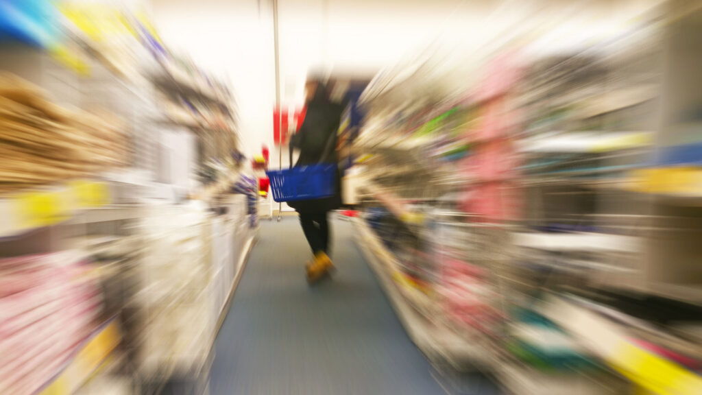 A motion blur view of a shopper losing balance during a slip and fall at big box stores in New York.