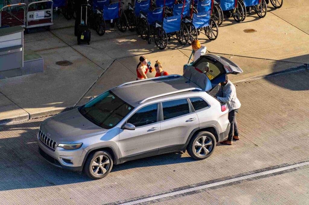 Passengers loading luggage into an SUV trunk demonstrating how insurance tiers apply in a NYC Lyft accident settlement.