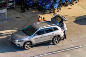 Passengers loading luggage into an SUV trunk demonstrating how insurance tiers apply in a NYC Lyft accident settlement.