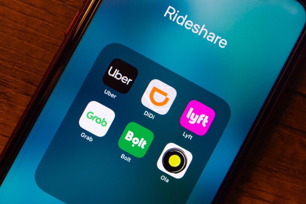 Smartphone screen showing rideshare icons including Lyft to explain how insurance tiers apply in a NYC Lyft accident settlement.