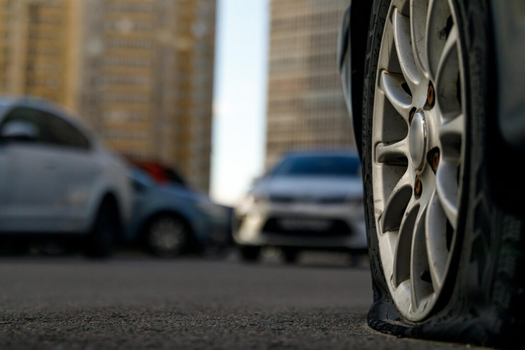 Close up of a flat tire on a damaged vehicle representing cases handled by New York DWI accident lawyers.