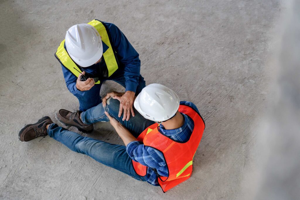 Obrero lesionado de la rodilla recibiendo auxilio en una obra para ilustrar los derechos de trabajadores indocumentados y accidentes de construcción en NY.